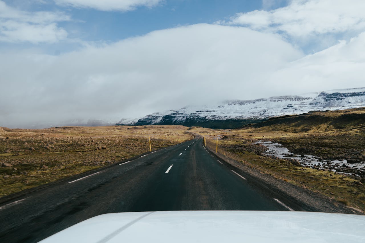 Tegemised Explore a picturesque road in Iceland with snow-capped mountains and vast landscapes.